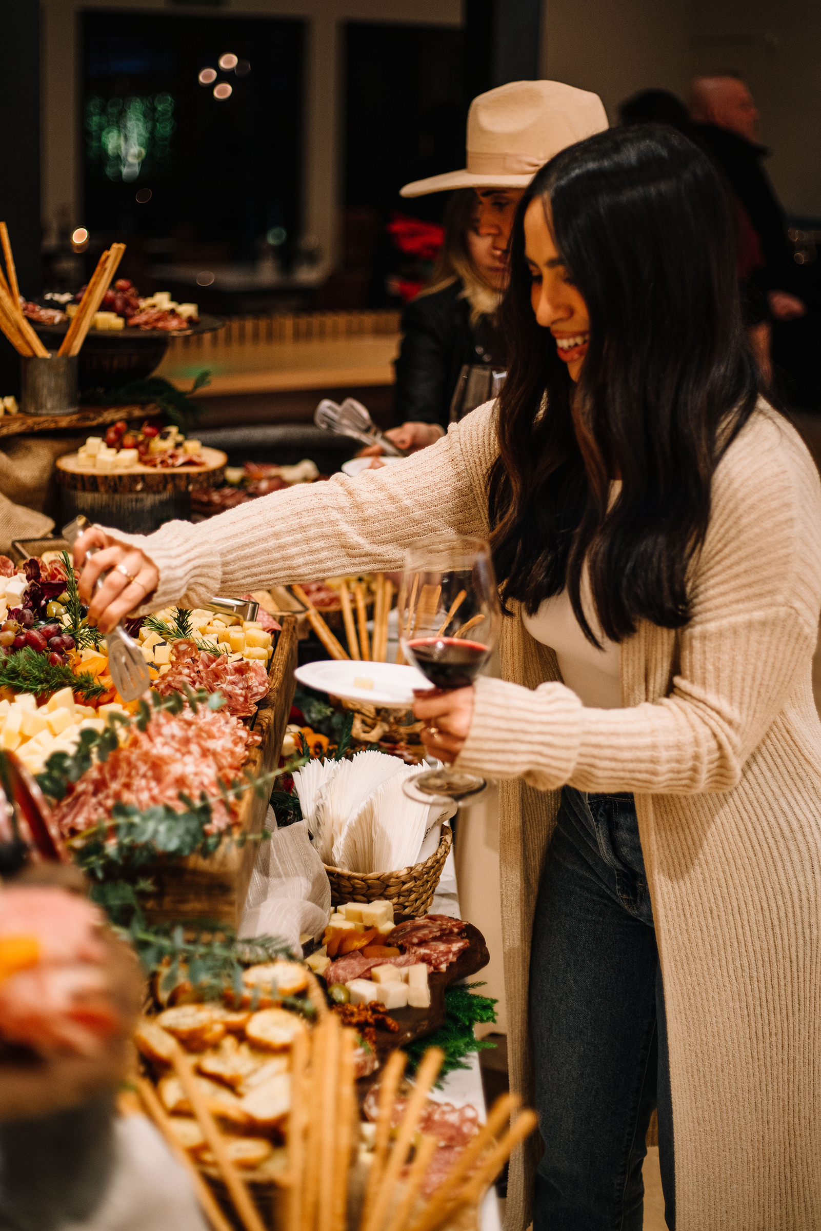Woman in foreground at cheese and charcuterie appetizer table