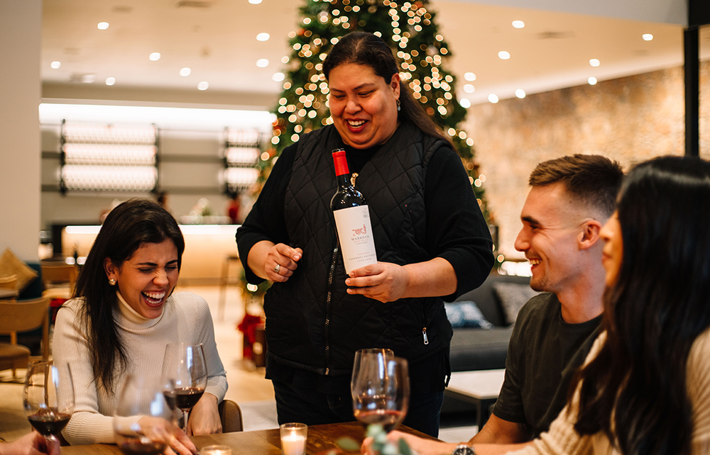 people being served in the Markham tasting room with holiday tree in background