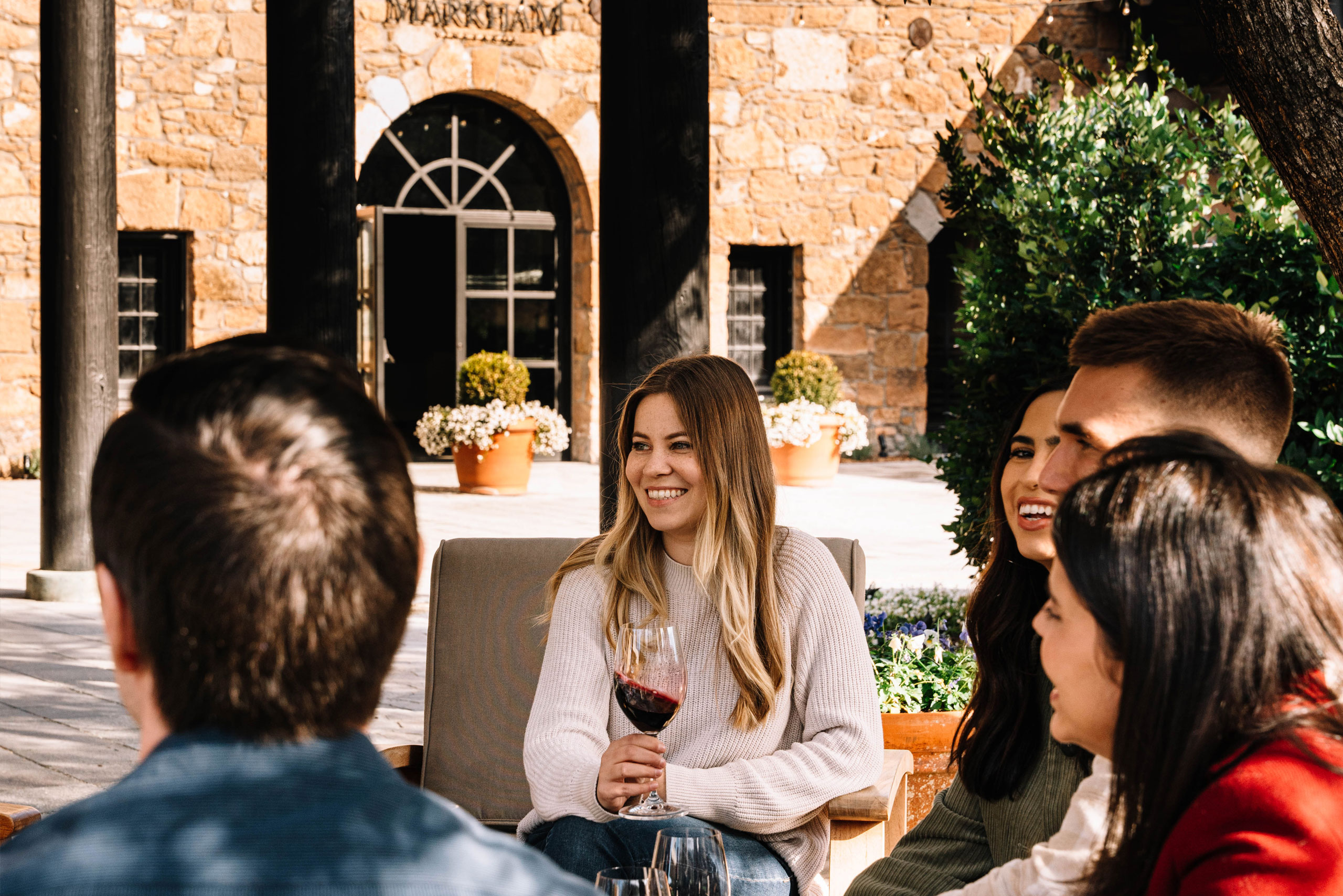 Group of people tasting wine with the Markham Stone Cellar in the background