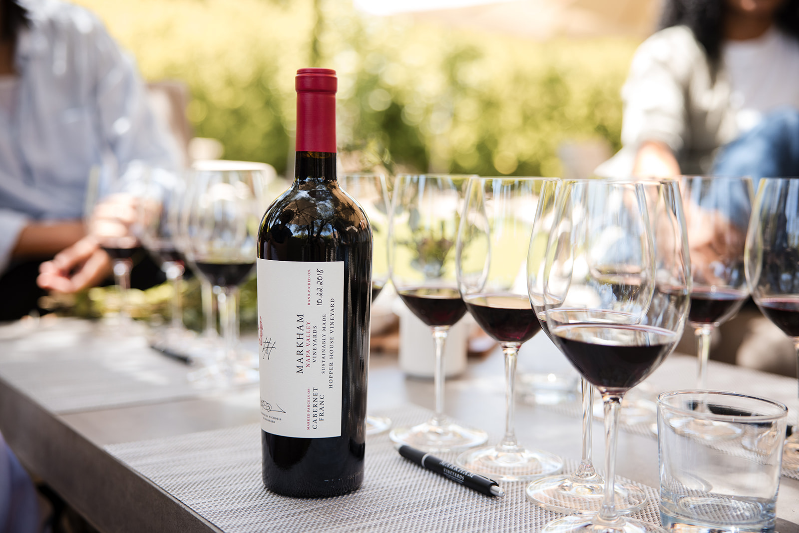 Glasses for tasting and a bottle of Markham on an outdoor table