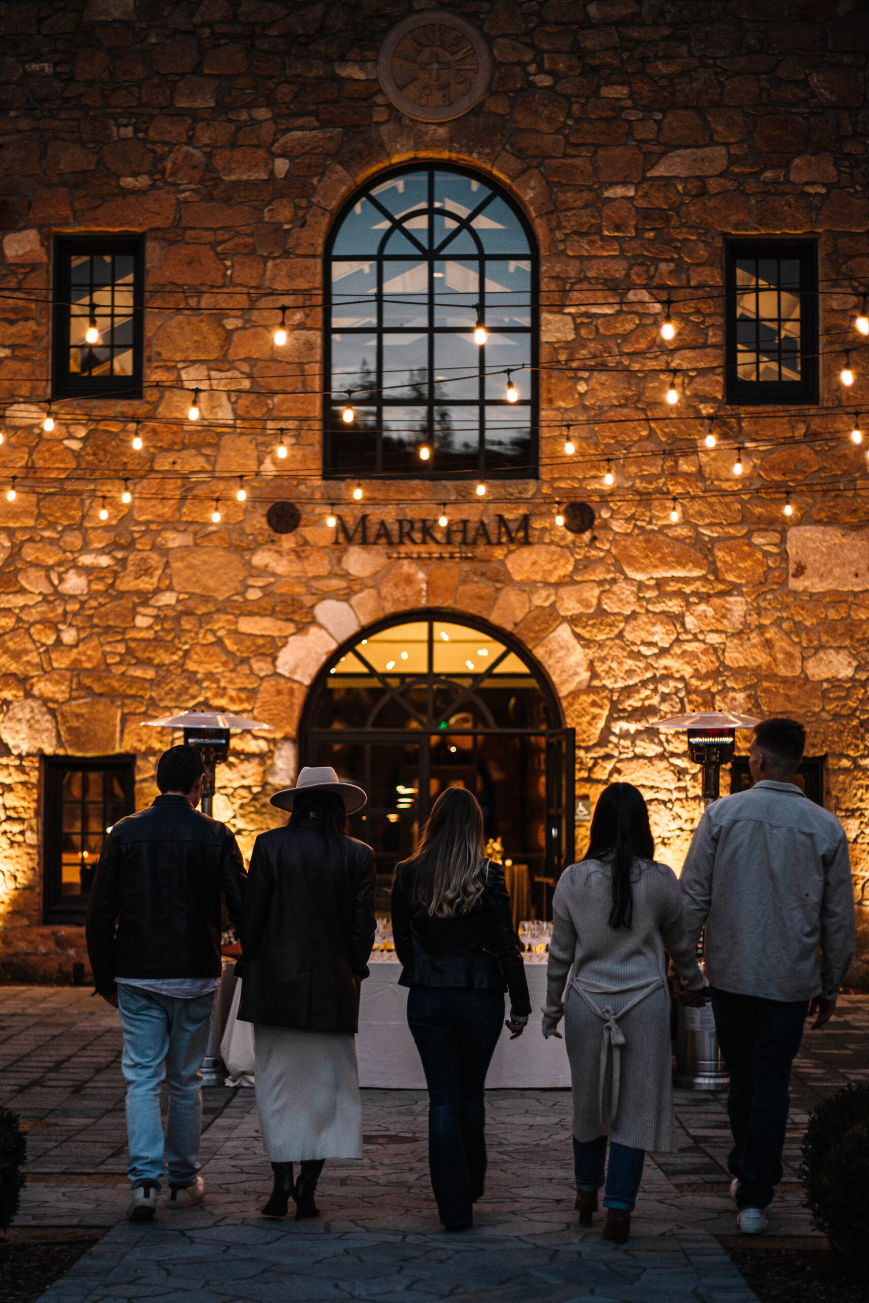 People walking towards entrance to Markham tasting room, back to the camera.
