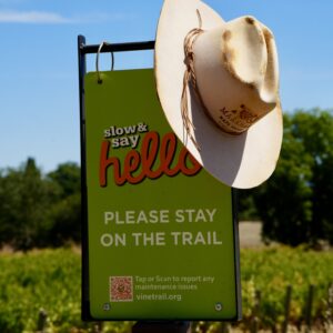 Markham cowboy hat resting on a Napa Valley Vine Trail sign.