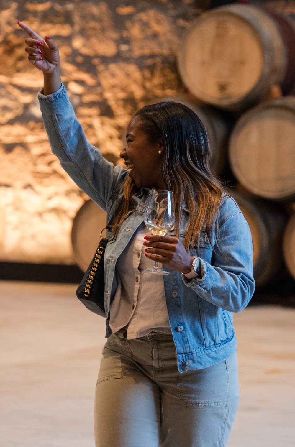 Person holding a glass of wine while line dancing in Markham's Historic Cellar