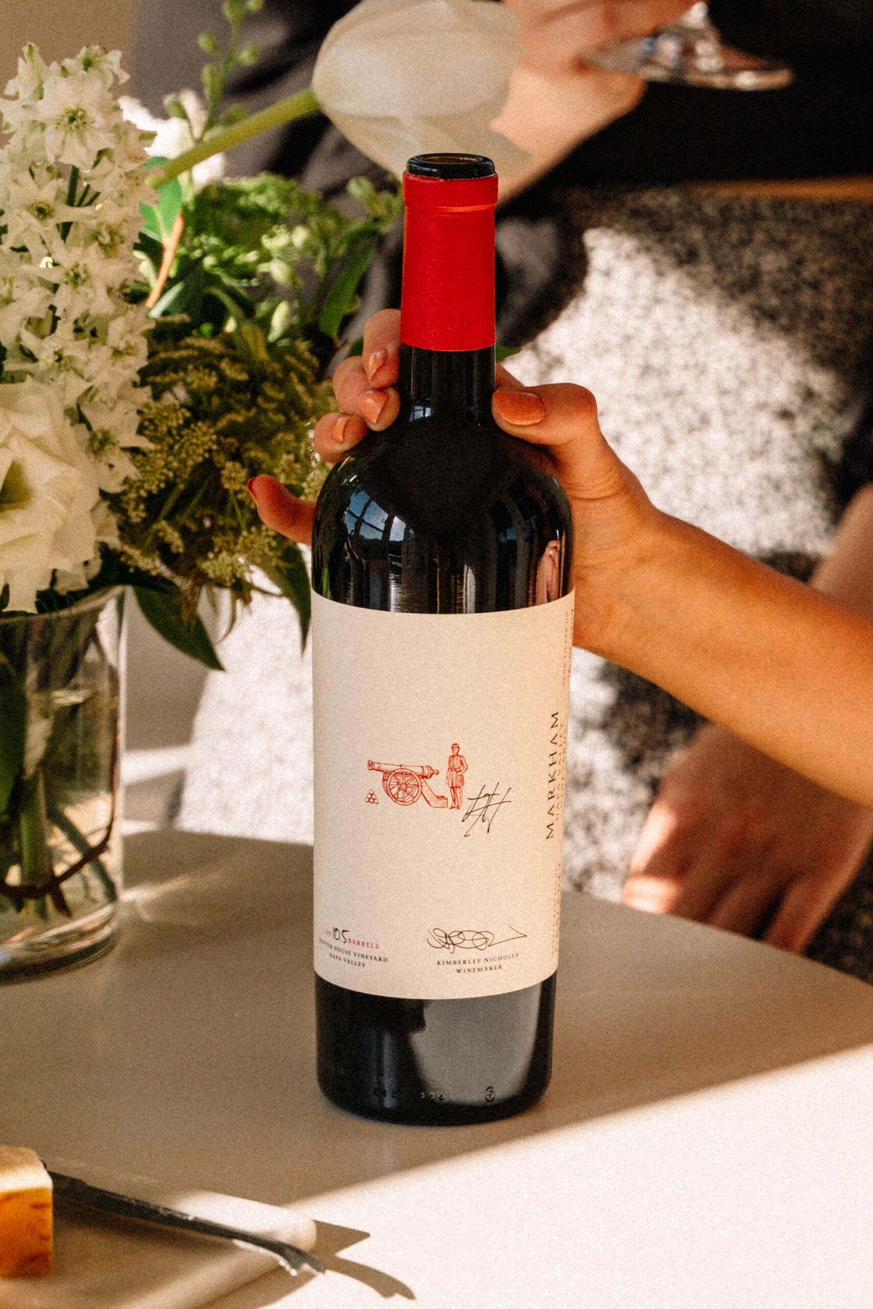 Bottle of Markham wine next to a flower arrangement